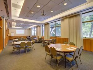 a conference room with tables and chairs and windows at Novotel RJ Santos Dumont in Rio de Janeiro