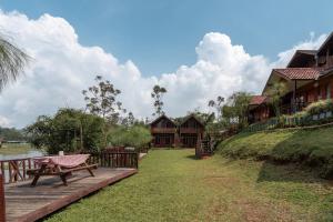 a resort with a picnic table and benches in the grass at RB Cottage Resort By ARBA in Palayangan