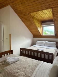 two beds in a room with a window at Guesthouse HYSA in Valbonë