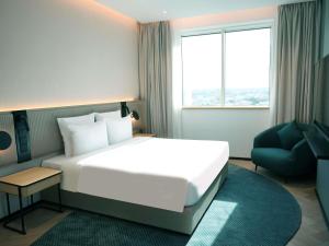 a hotel room with a large bed and a chair at Novotel Riyadh Al Anoud in Riyadh +111 photos