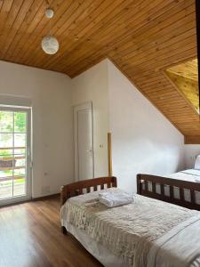a bedroom with two beds and a wooden ceiling at Guesthouse HYSA in Valbonë