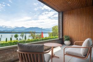 a balcony with a table and chairs and a view of the water at Rigi Lakeside Apartments in Merlischachen