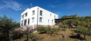 a white building on top of a hill with trees at AmarMare Bed&Breakfast in Trappeto