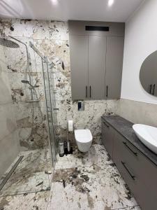 a bathroom with a shower and a toilet and a sink at Apartament nad jeziorem Rosnowo in Rosnowo +13 photos