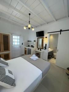 a bedroom with a large white bed and a bathroom at Summer Dream 1 in Agios Prokopios