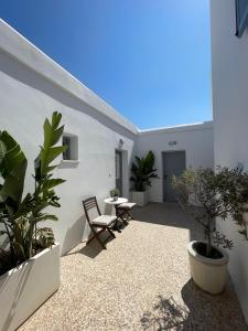 a patio with two chairs and a table and some plants at Summer Dream 1 in Agios Prokopios