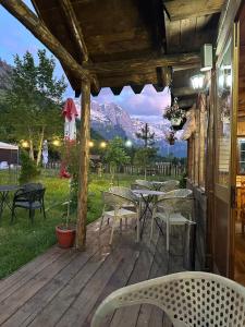 a patio with tables and chairs on a deck at Guesthouse HYSA in Valbonë