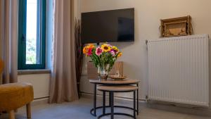 eine Vase mit Blumen auf einem Tisch in einem Zimmer in der Unterkunft Porto Juno in Portianón