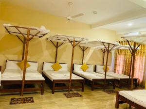 a room with four beds and umbrellas at Hotel Nilketha Yala Tissamaharama in Tissamaharama +129 photos