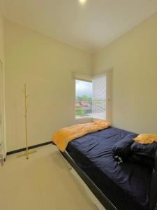 a bedroom with a large bed with a window at infinite 88 villa in Batu