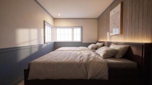 a large bed in a room with a window at Ruhe K in Kusatsu