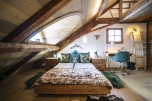 ein Schlafzimmer im Dachgeschoss mit einem Bett und einem Schreibtisch in der Unterkunft Chasa Sentima in Sent