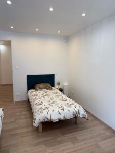 a bedroom with a bed in a white wall at Gîte Région des Lacs - SPA et Sauna Privatif in Orgelet