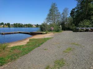 a road next to a lake with a stop sign at EFS-gården in Åsljunga