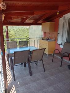 a patio with a table and chairs and a kitchen at Villa Fraoulitsa in Skoutari