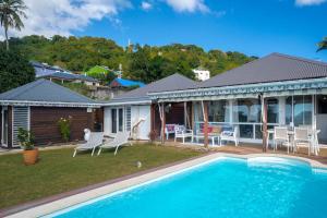 a house with a swimming pool in the yard at Villa Le Nid des Colibris in Gourbeyre