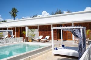 a white house with a swimming pool and a house at ZAN Orient Bwejuu Hotel in Makunduchi