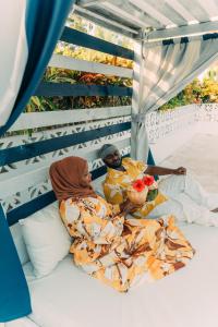 two people laying on a bed in a tent at ZAN Orient Bwejuu Hotel in Makunduchi