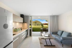 a kitchen and living room with a couch and a table at Sun et Sea Dreams in Anse Marcel 
