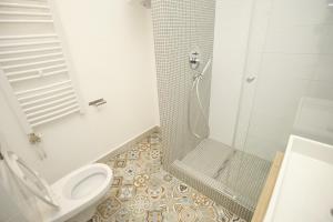 a white bathroom with a toilet and a shower at TRAMVAJ Apartments in Belgrade +26 photos