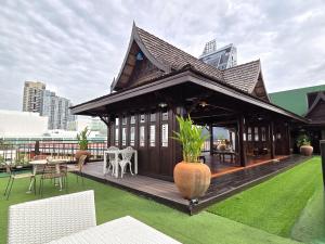 a building with a deck with a table and chairs at True Siam Rangnam Hotel in Bangkok