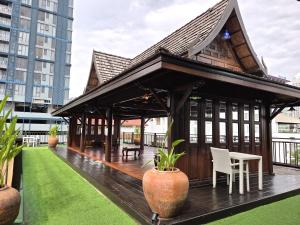 a pavilion with a table and chairs on a roof at True Siam Rangnam Hotel in Bangkok