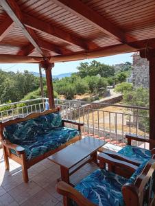 a porch with a table and chairs and a view at Villa Fraoulitsa in Skoutari