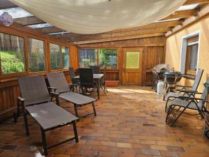 a room with chairs and a table and windows at Haus Burgblick in Obertrubach