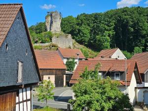 a village with houses and a castle in the background at Haus Burgblick in Obertrubach
