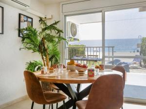 a dining room with a table and chairs with a view of the ocean at GENIETEN OP HET STRAND in Miami Platja