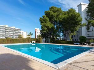 a large blue swimming pool with trees and buildings at GENIETEN OP HET STRAND in Miami Platja