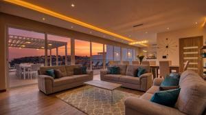 a living room with couches and a dining room and a kitchen at Villa Gaia - Sunset Views, Indoor Heated Pool, Sauna and Games Room in Mellieħa