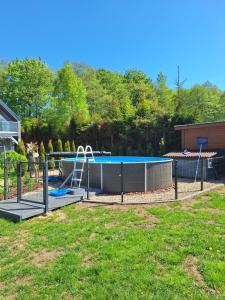 a swimming pool with a slide in a yard at Sowi Kąt - Domki z Baliami oraz Tradycyjne in Lubiatowo