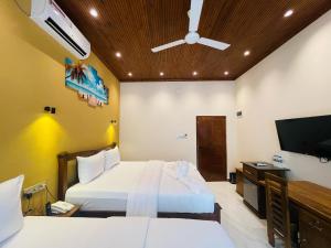 a hotel room with two beds and a flat screen tv at Infenta's Villa Hotel & restaurant in Pandattarippu