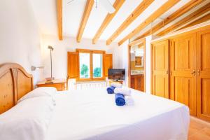 a bedroom with a large white bed with wooden cabinets at Casa Can Pauma in Caʼs Concos +37 photos