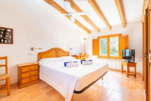 a bedroom with a large bed and a television at Casa Can Pauma in Caʼs Concos