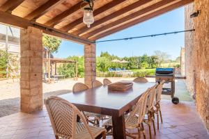 a wooden table and chairs on a patio with a grill at Casa Can Pauma in Caʼs Concos