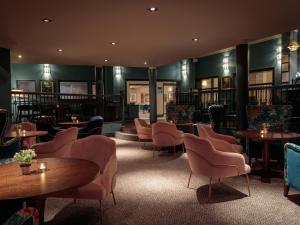 a library with tables and chairs and bookshelves at Mercure Blackburn Dunkenhalgh Hotel & Spa in Blackburn