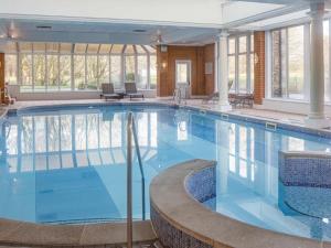 a large pool with blue water in a building at Mercure Blackburn Dunkenhalgh Hotel & Spa in Blackburn