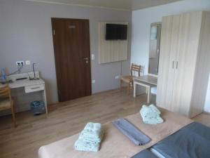 a room with a bed and a desk and a table at Pension Zur Eiche in Drebenstedt