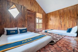 two beds in a room with wooden walls at RB Cottage Resort By ARBA in Palayangan +27 photos