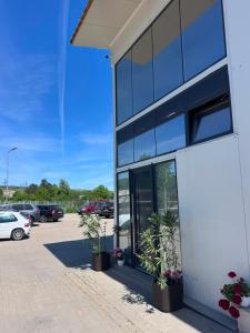 a white building with plants in a parking lot at Oxygen Rooms in Hunedoara