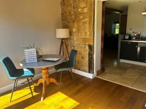 a kitchen with a table and chairs in a room at Waterside Cottage in Harrogate