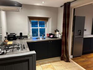 a kitchen with a sink and a stove top oven at Waterside Cottage in Harrogate +11 photos