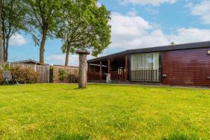 a house with a tree in the yard at Grasheide: Modern in Drenthe (4p) in Erm