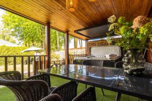 a table and chairs on a screened porch with a table and flowers at Grasheide: Modern in Drenthe (4p) in Erm