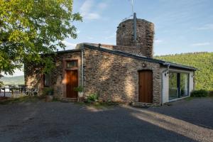 a stone house with a chimney on the side of it at Mosel Panorama Studio auf Burg Coraidelstein in Klotten