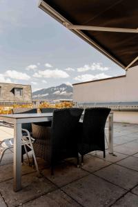 a table and chairs on a patio with a view at Los Lorentes Residences Bulle in Bulle