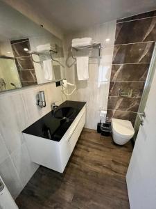 a bathroom with a black sink and a toilet at Kent Suites Hotels Ataşehir in Istanbul +29 photos