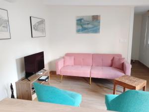 a living room with a pink couch and a tv at Xeitosa II, en el centro de Vigo in Vigo